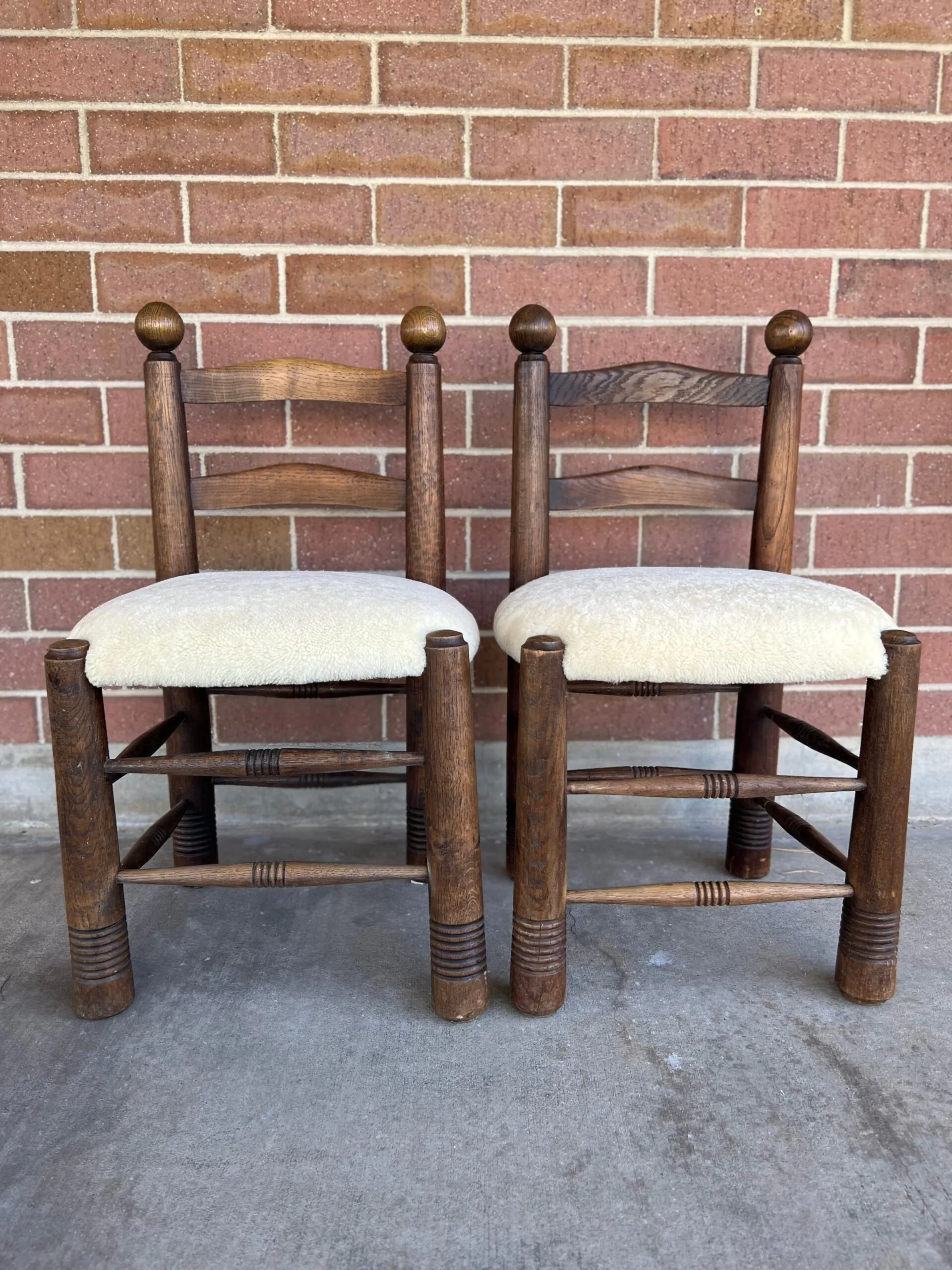Pair of rustic ladder-back chairs reupholstered with cream bouclé seats